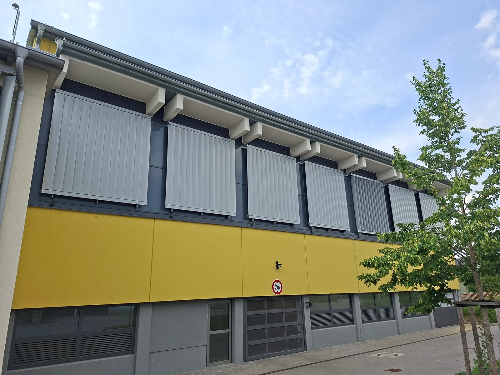 KNX Sonnenschutz in der Turnhalle Altdorf: Mit Quadra® und MCU-04X-Box AC führt BMS Großlamellen blendfrei nach, für faire Wettkampfbedingungen.